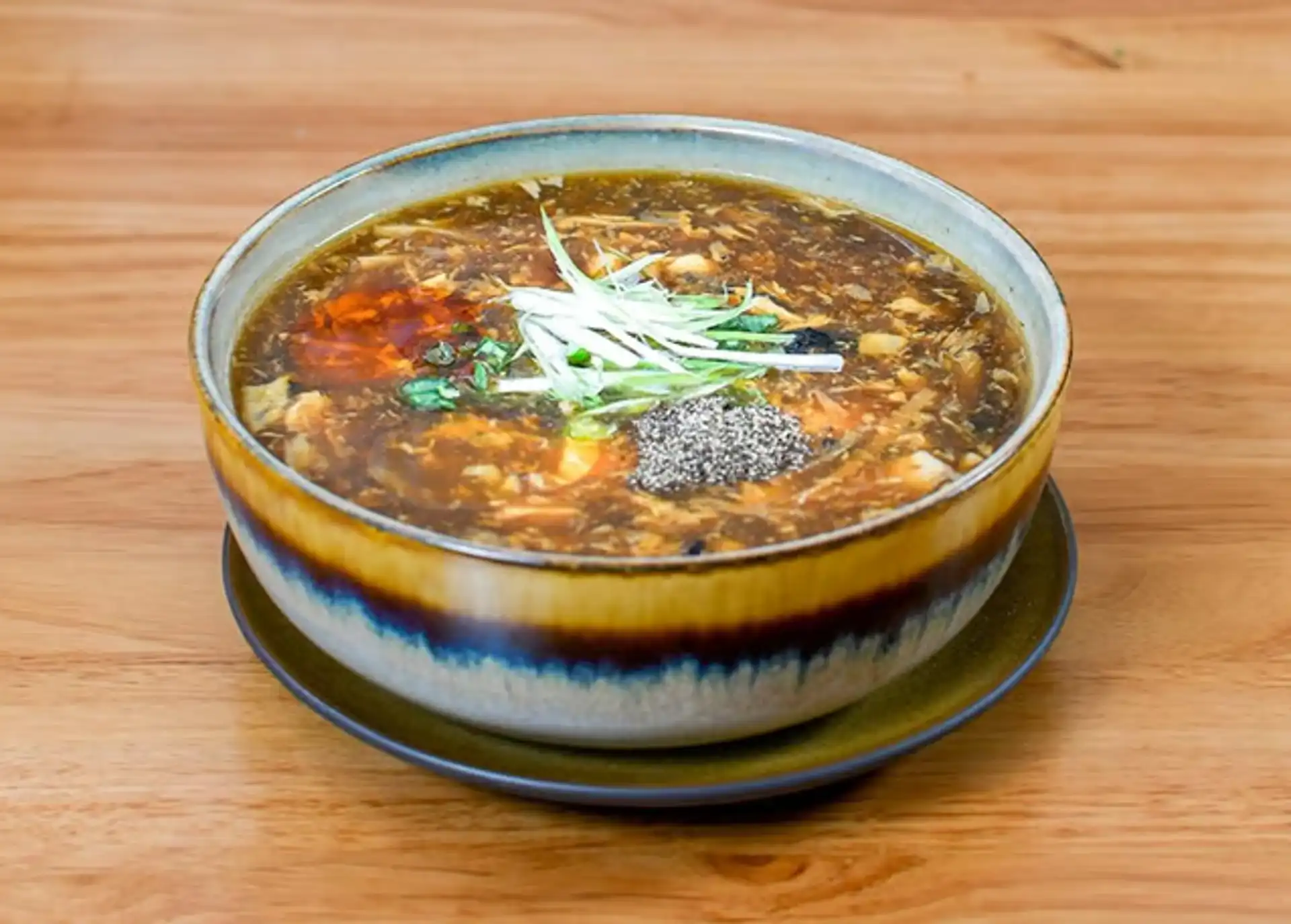 Ugly Dumpling hot and sour soup — thick tangy broth with tofu, mushrooms, bamboo shoots, and egg ribbons